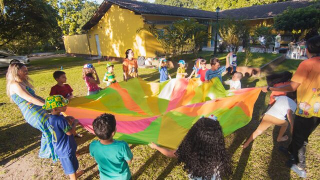 children playing with a colourful parachute at a summer outdoor event